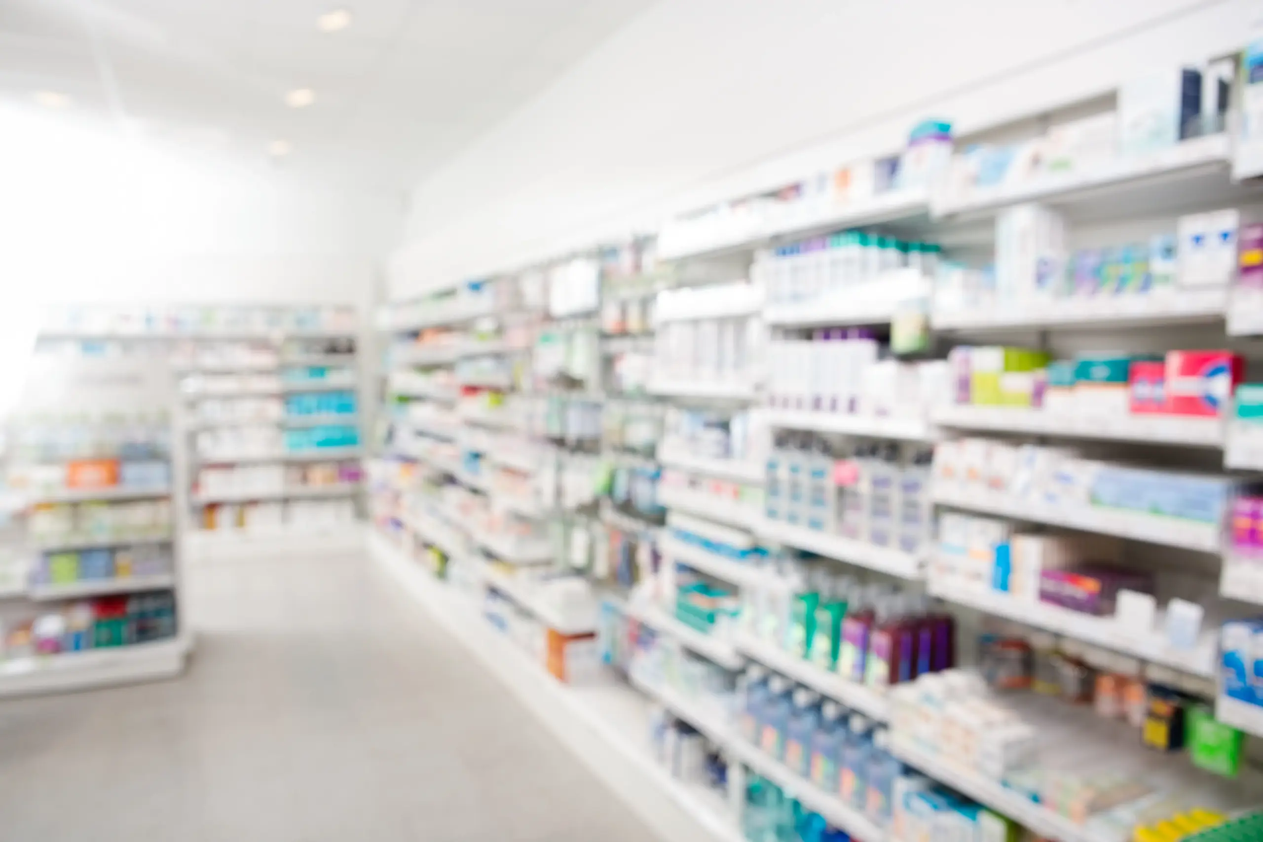 Scaffale farmacia con scatole di medicinali, farmaci da banco e prodotti sanitari.